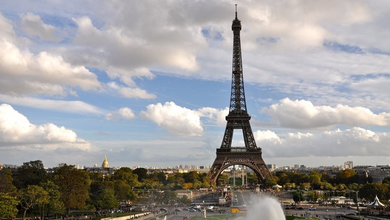 Der Eiffelturm vor blauem Hmmel und Schäfchenwolken