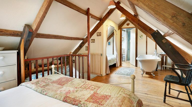 Typisch walisisches Schlafzimmer unter dem Dach mit freistehender Badewanne