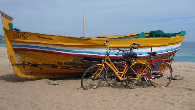 Fahrrad an Boot gelehnt am Meer in Spanien
