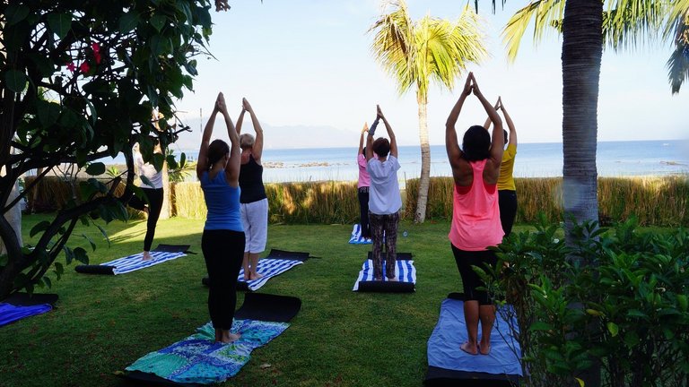 Frauen im Urlaub machen Yoga-Asans im Freien mit Blick auf das kretische Meer