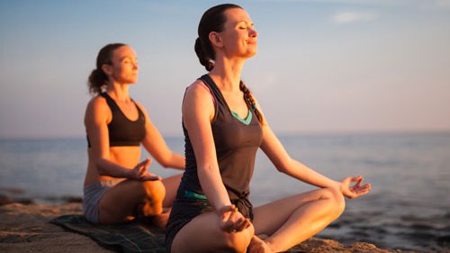 Frauen machen Yoga am Sandstrand