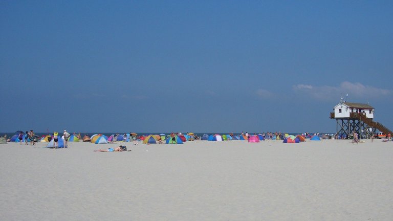 Großer Strand mit Pfahlbauten bei St. Peter Ording