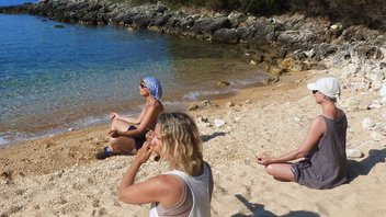 Alleinreisende Frauen beim morgendlichen Yoga am Strand
