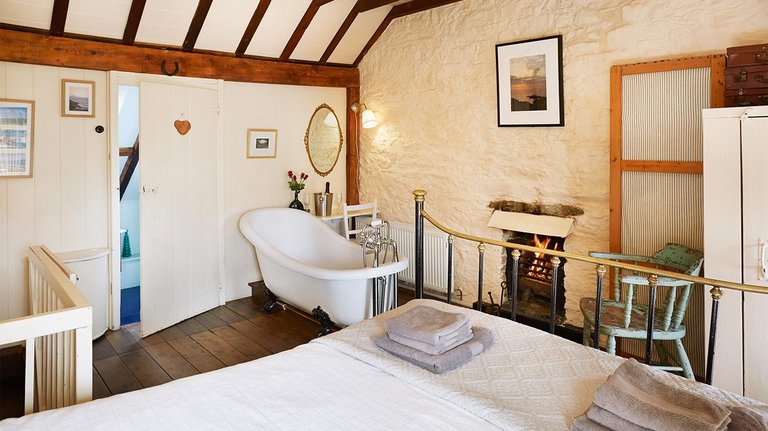 Frestehende Badewanne in gemütlichem Schlafzimmer in walisischem Landhaus