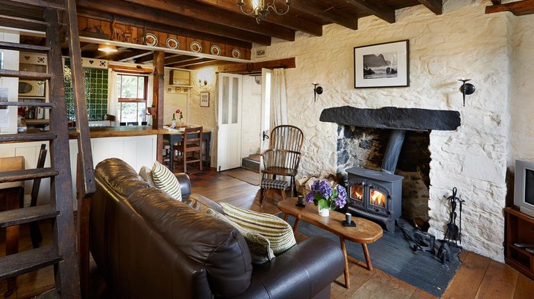 Wohnzimmer mit offenem Kamin in walisischem Cottage