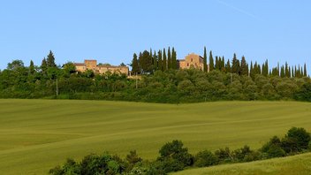 Typische toskanische Landschaft mit Zypressen und Steinhäusern