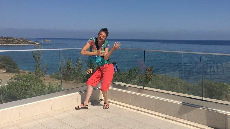 Frau tanzt auf Terrasse im Strandhotel auf Zypern