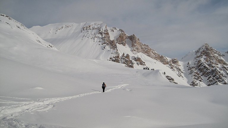 Frau mit Schneeschuhen vor Bergkulisse