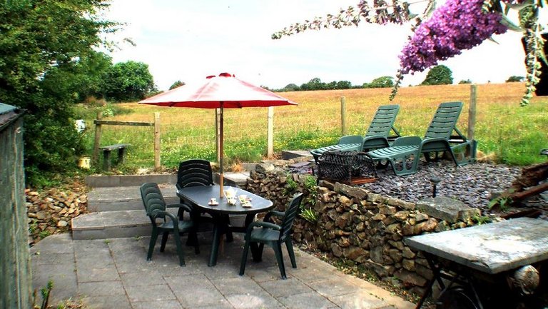 Sitzplatz mit rotem Sonnenschirm und Blick in die walisische Landschaft